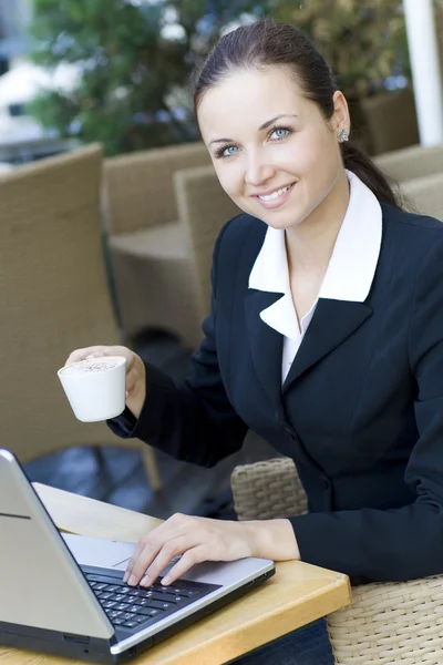 Donna con computer portatile bere caffè — Foto Stock