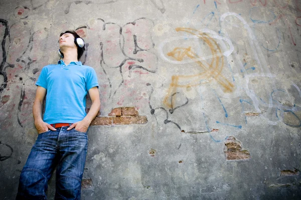 Man leaning against wall with graffiti — Stock Photo, Image