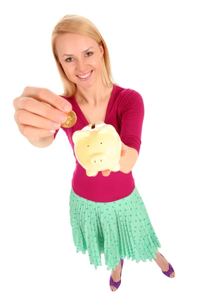 Woman putting coin in piggy bank — Stock Photo, Image