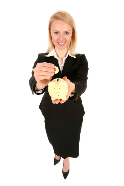 Empresária colocando moeda em banco porquinho — Fotografia de Stock