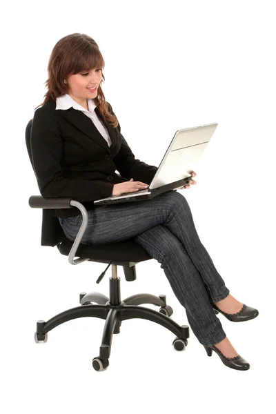 Businesswoman sitting in office chair with laptop — Stock Photo, Image