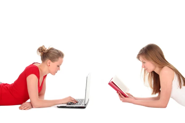 Zwei Frauen legen sich mit einem Buch und einem Laptop hin — Stockfoto