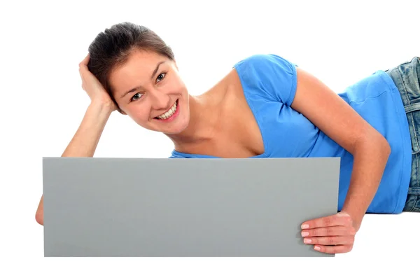 Woman lying down and holding blank poster — Stock Photo, Image