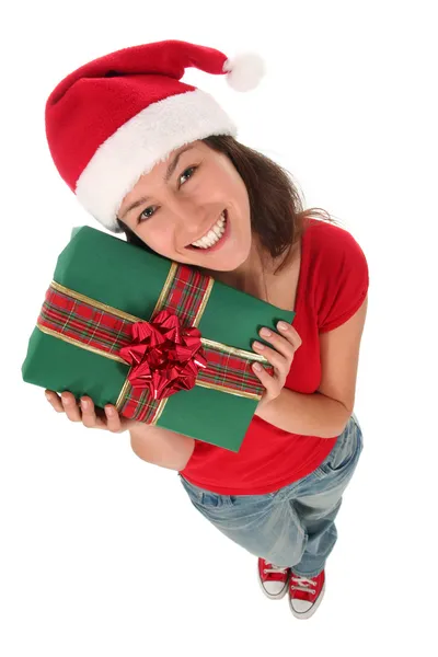 Jonge vrouw dragen een kerstmuts, houden een geschenk — Stockfoto