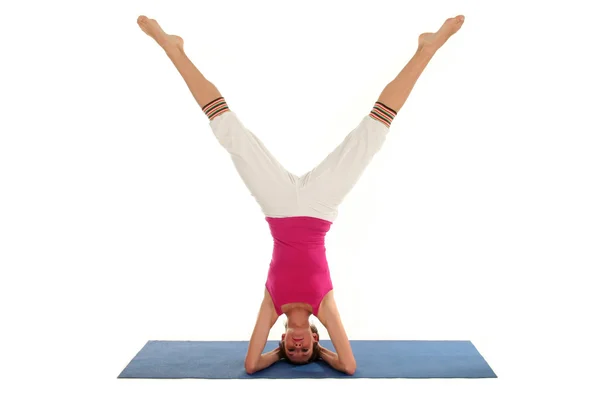 Vrouw doen een headstand op een yoga mat — Stockfoto