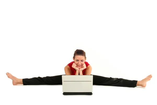 Mujer haciendo una división y utilizando el ordenador portátil — Foto de Stock