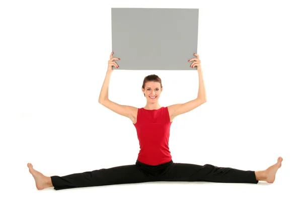 Woman with blank card doing a split — Stock Photo, Image