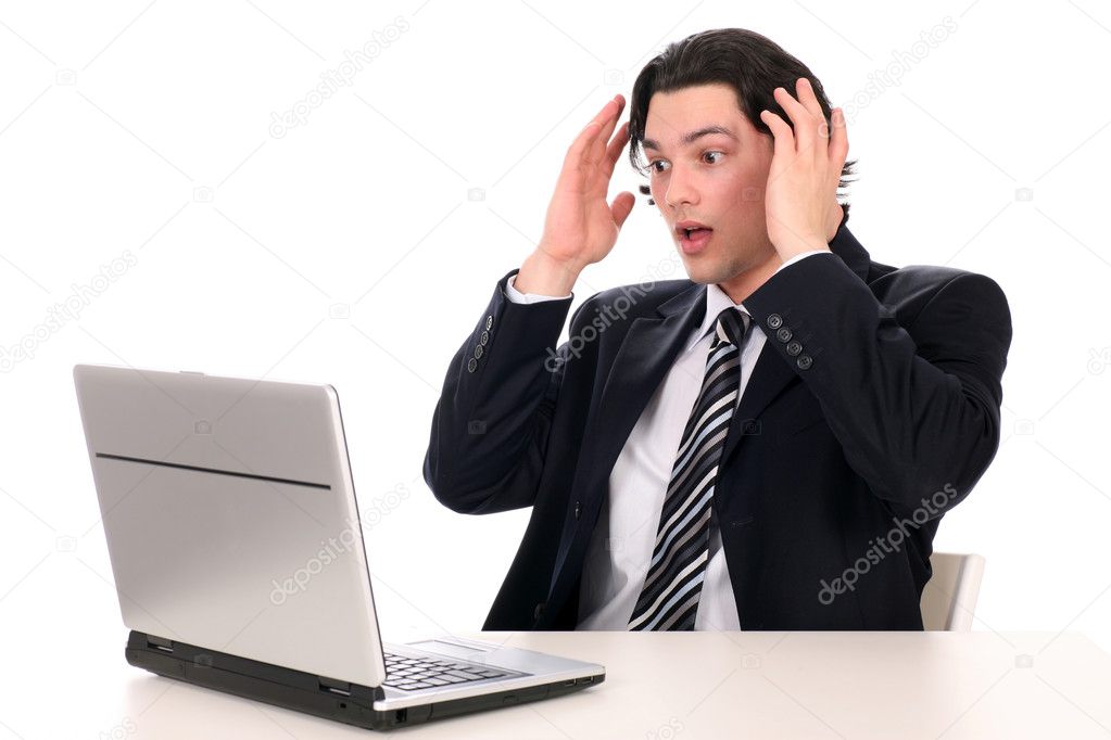 Businessman with laptop, holding head in hands