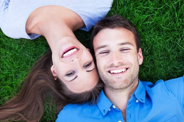 年轻夫妇躺在草地上 — 图库照片