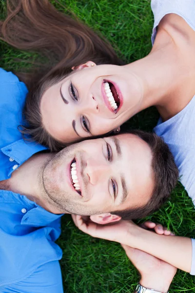 Jeune couple couché sur l'herbe — Photo