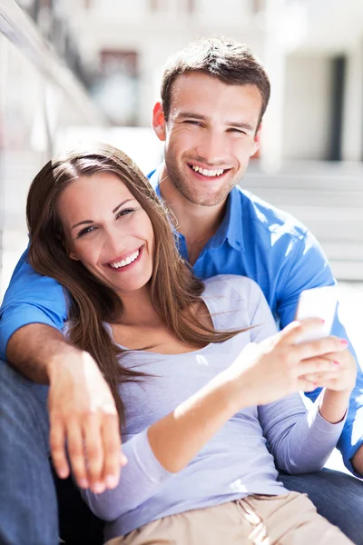 Couple souriant avec téléphone portable — Photo