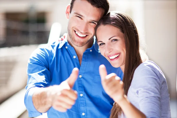 Lächelndes Paar mit erhobenem Daumen — Stockfoto