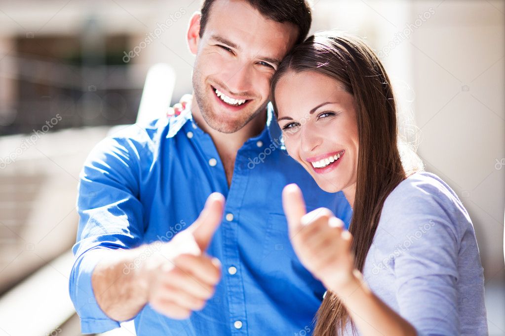 Smiling couple with thumbs up