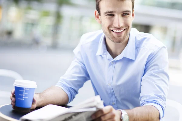 Uomo che legge il giornale al caffè all'aperto — Foto Stock