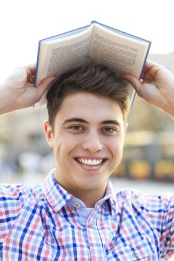 genç adamın başının üstünde kitap