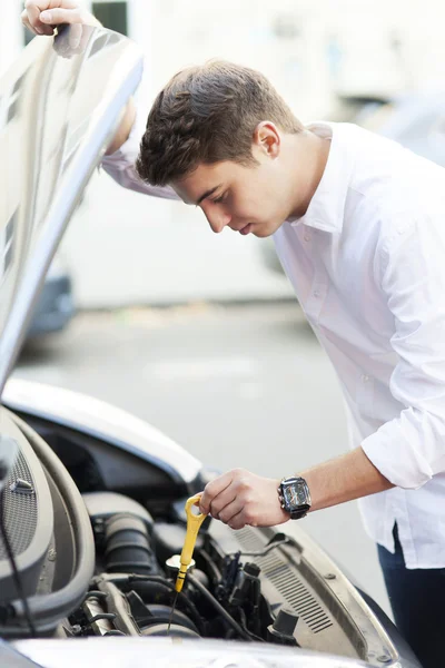 Uomo che controlla il livello dell'olio in auto — Foto Stock