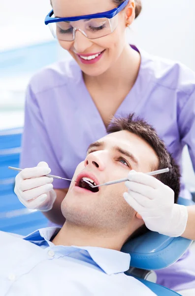 Dentista feminina e paciente em consultório odontológico — Fotografia de Stock