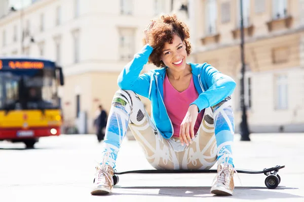 Frau sitzt auf Skateboard — Stockfoto