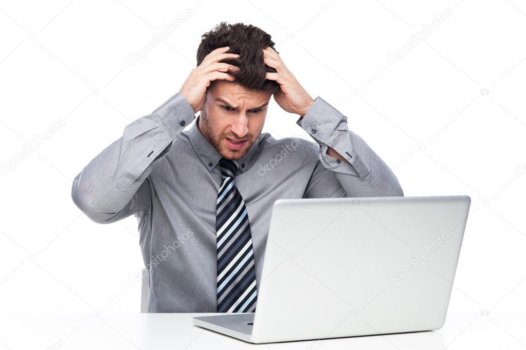 Stressed man looking at laptop