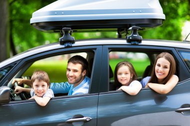 Happy family sitting in the car clipart