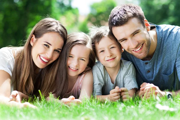 Familjen ligga utomhus på gräs — Stockfoto