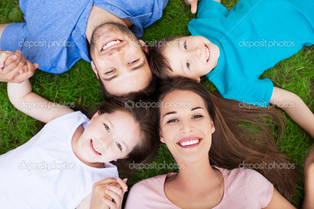 Young family lying on grass