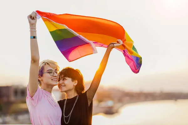 幸せな非バイナリカップルの肖像虹の旗を振って — ストック写真