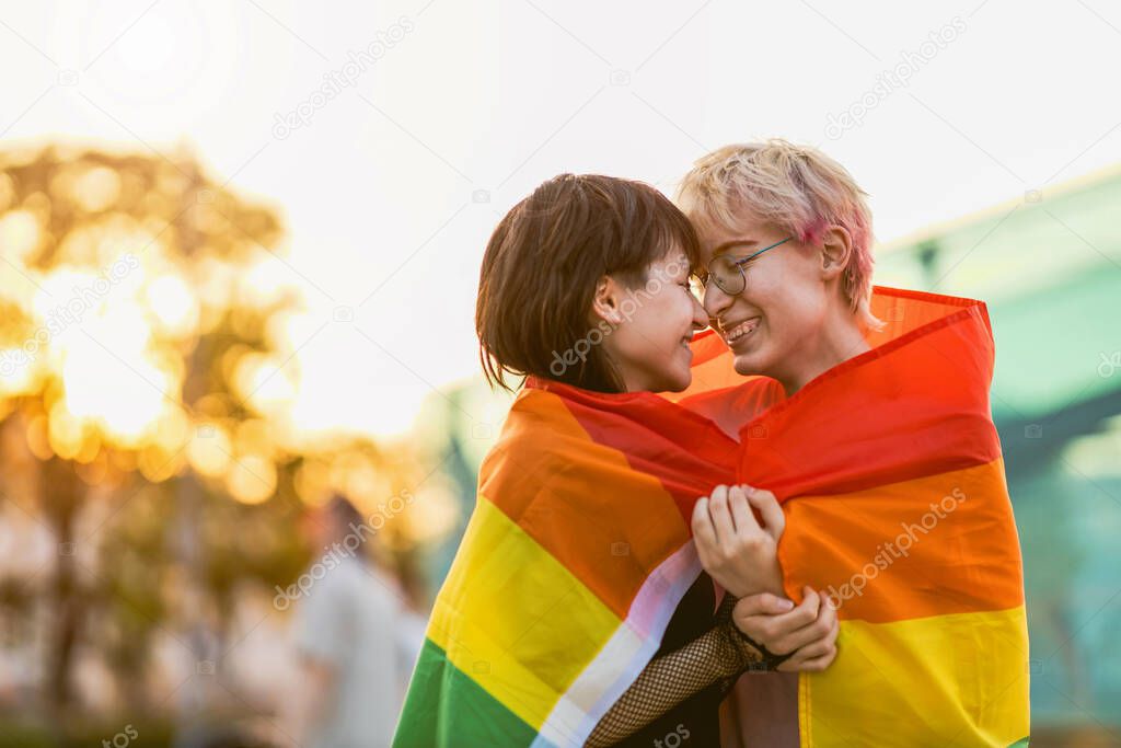 Portrait of a gender fluid couple wearing rainbow flag