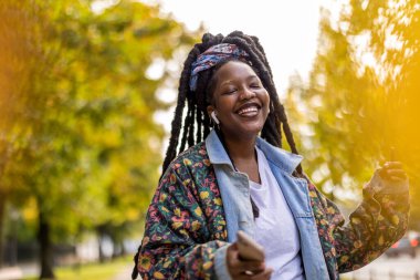 Genç bir kadın dans etmekten ve açık havada müzik dinlemekten hoşlanıyor.