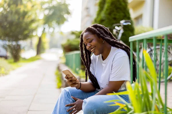 Attractive Young Woman Using Her Smartphone Outdoors Stock Photo