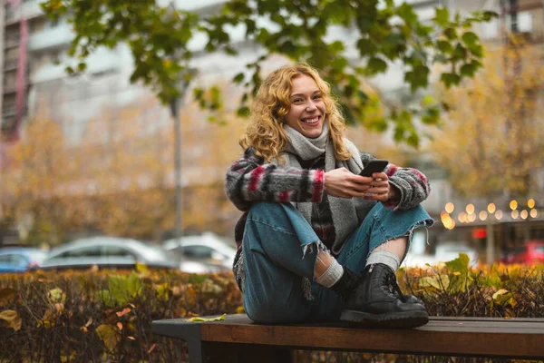 Portret Uśmiechniętej Młodej Kobiety Mieście Trzymającej Telefon Komórkowy — Zdjęcie stockowe