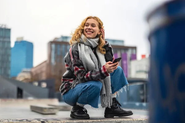 Şehirde Elinde Cep Telefonu Olan Gülümseyen Genç Bir Kadının Portresi — Stok fotoğraf