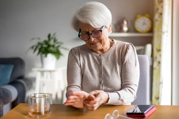 Seniorin Mit Arthritis Reibt Sich Die Hände — Stockfoto