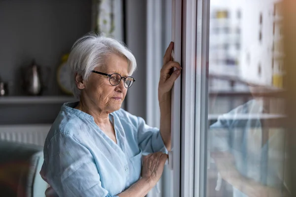 Senior Woman Looking Out Window Home Stock Photo