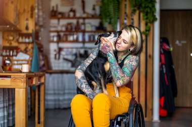 Evde köpeği olan engelli genç bir kadın.