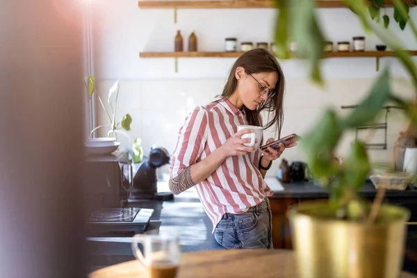 Mujer Joven Usando Teléfono Inteligente Mientras Está Pie Cocina Casa — Foto de Stock