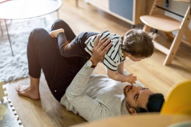 Baba, küçük oğluna evde bakıyor.