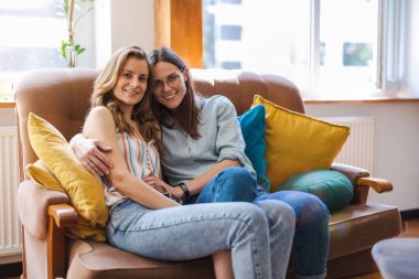 Evde kucaklaşan sevecen lezbiyen çiftin portresi.