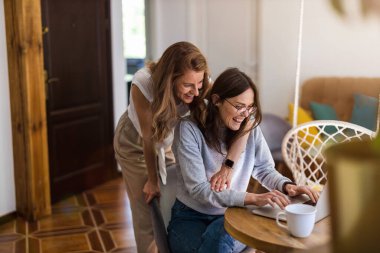 Evde dizüstü bilgisayar kullanan lezbiyen çift