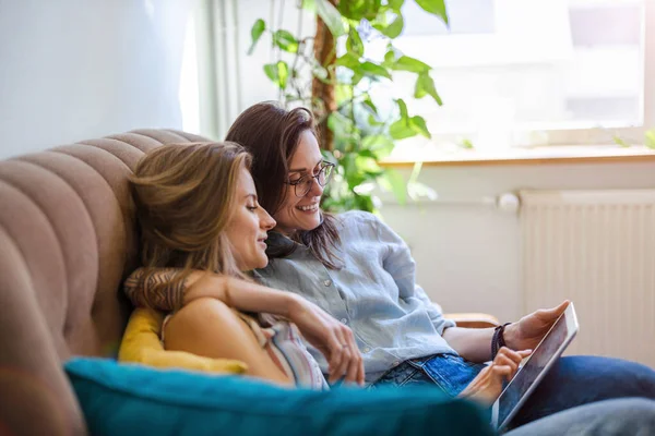 Lesbisches Paar Sitzt Auf Einem Sofa Und Benutzt Ein Tablet — Stockfoto