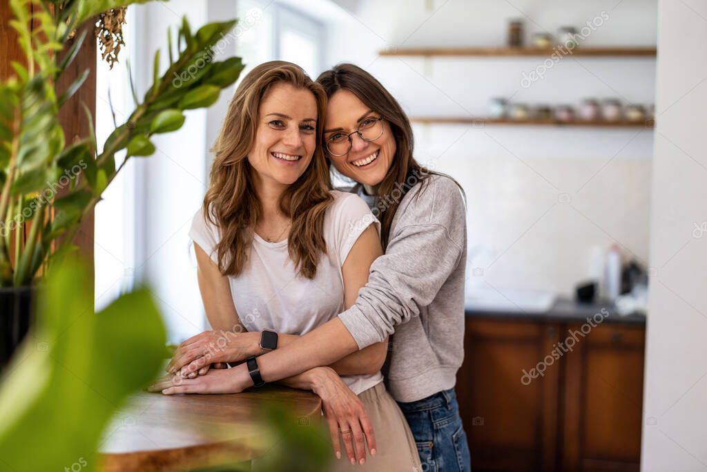 Portrait of affectionate lesbian couple embracing at home
