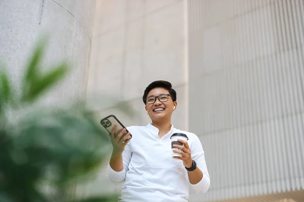 Smiling young man using mobile phone