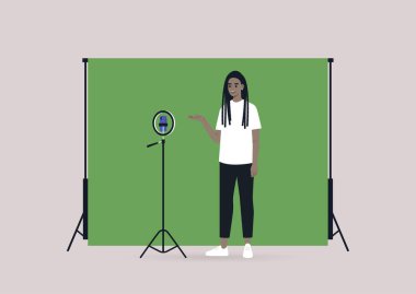 Genç bir Afrikalı kadın blogcu tripodla, cep telefonuyla ve kroma ekran anahtarıyla video kaydediyor.