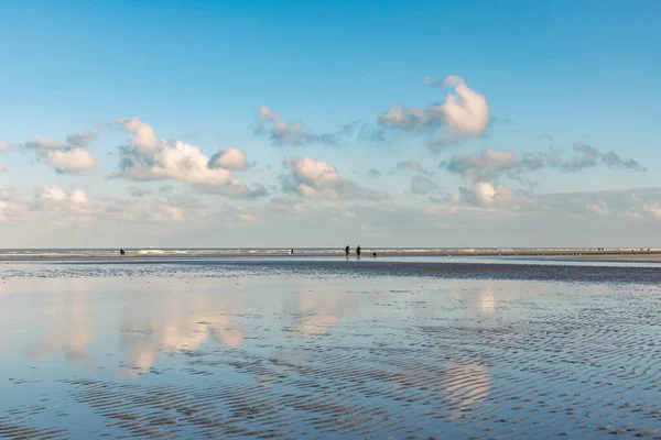 Oostduinkerke, Bélgica - 6 de enero de 2022: Turistas caminando por la costa en una fría mañana de inviernos — Foto de Stock