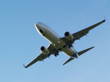Mavi gökyüzü arka plan üzerinde beyaz bir uçak