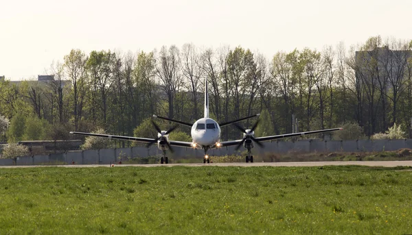 Weißes Turboprop-Flugzeug auf der Landebahn, Frontansicht — Stockfoto