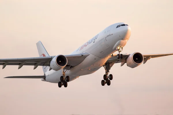 Departing MASkargo Airbus A330-223F aircraft in the sunset rays — Stock Photo, Image