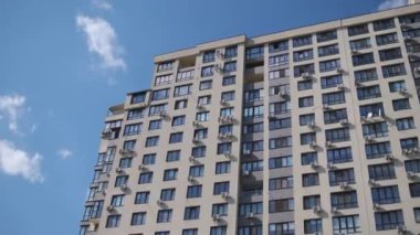 Mavi gökyüzüne karşı çok katlı, modern bir bina..