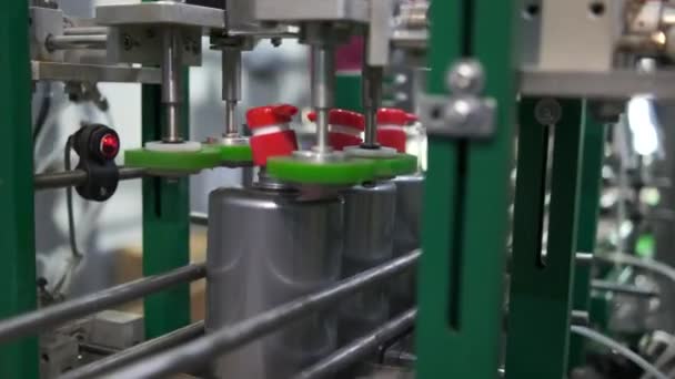 Una empresa para la producción de detergentes para el hogar. La máquina tuerce un tapón rojo con un dispensador en una botella de plástico gris con líquido. línea transportadora . — Vídeo de stock