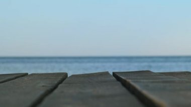 Bulanık mavi deniz ve gökyüzünün arka planına yakın olan eski bir ahşap iskele. Panoramik pankart - boşluğu kopyala.